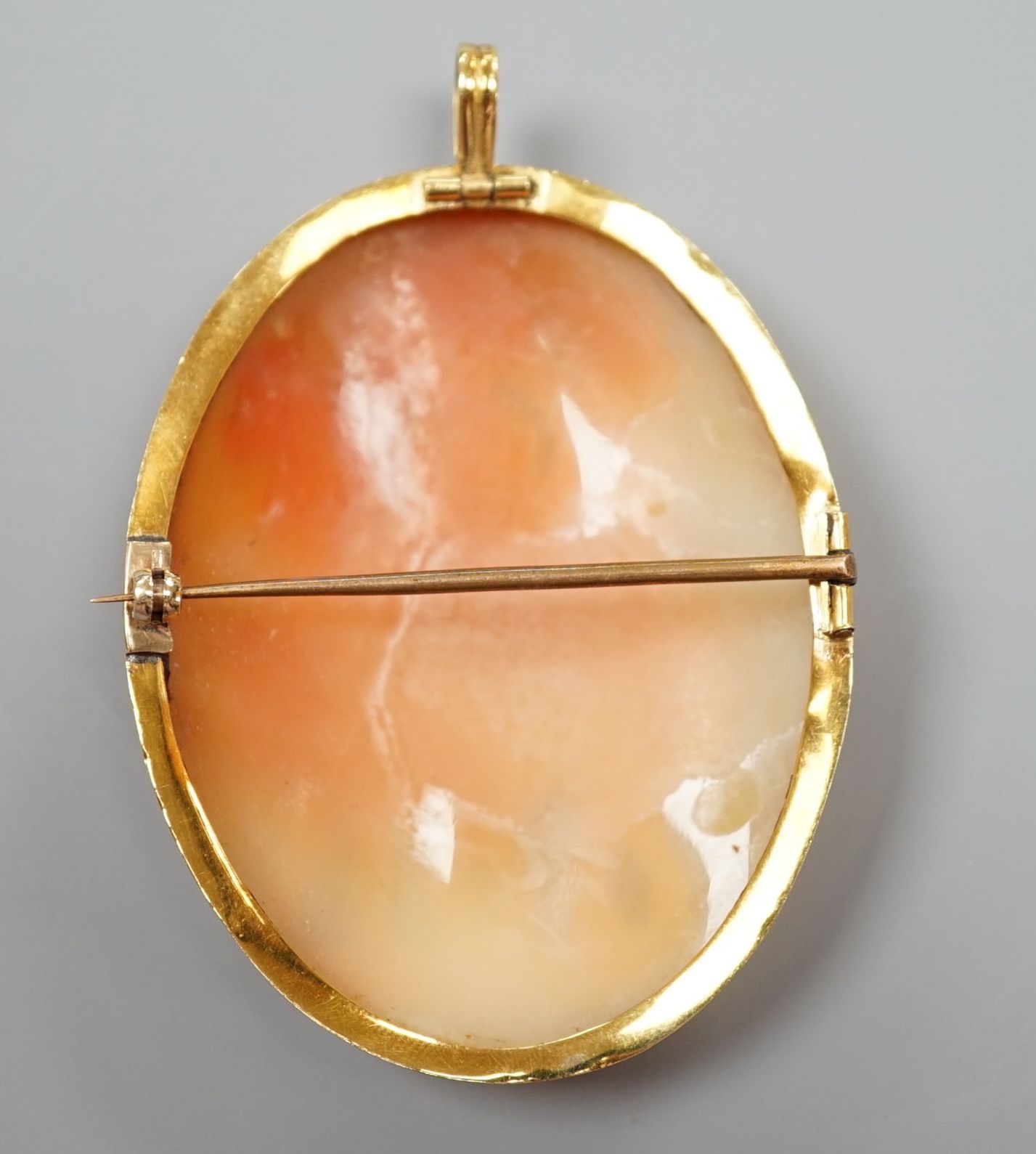 A yellow metal mounted oval cameo shell pendant brooch, carved with The Three Graces, 62mm, gross weight 21.4 grams.